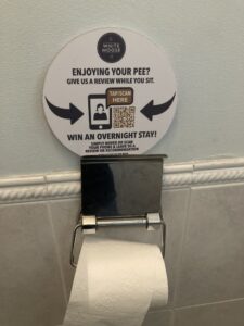 White Moose Cafe point of sale sign inviting you to leave a review. In the toilet.
